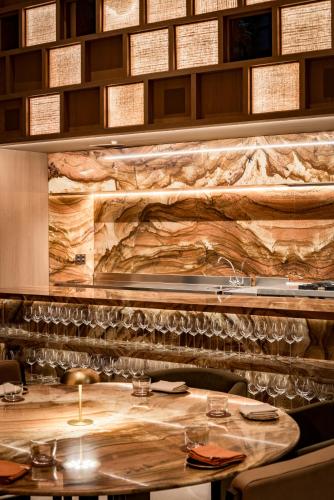 a table in a restaurant with a stone wall at Emiliano São Paulo in São Paulo