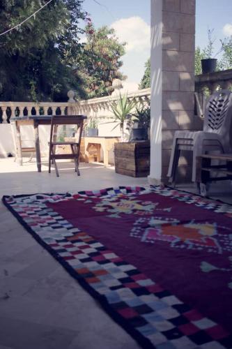 a rug on a patio with a table and a piano at Atelier Meso in Le Kram