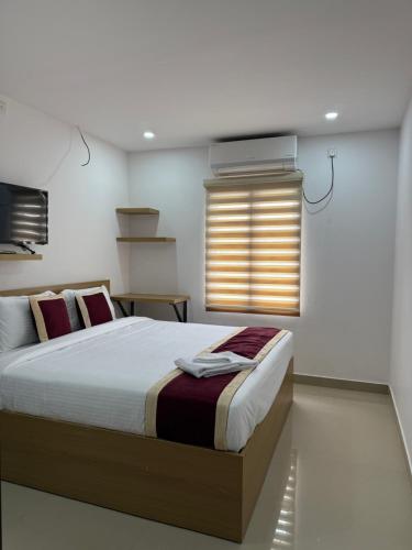 a bedroom with a large bed and a window at Aero Inn in Nedumbassery