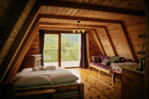a bedroom in a log cabin with a bed and a window at Elagza Dag Evi in Rize