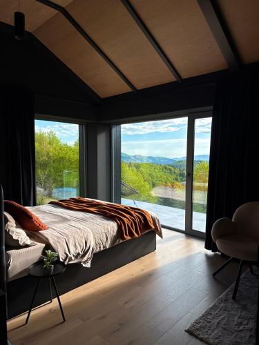 a bedroom with a bed and a large window at Nordic Star Chalet in Fundata
