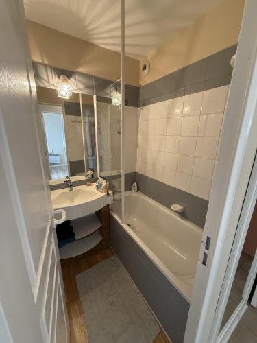 a bathroom with a tub and a sink and a bath tub at Les balcons de Valmi vue montagne Piscine in Valmeinier