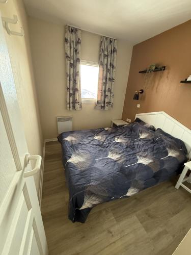 a bedroom with a bed and a window at Les balcons de Valmi vue montagne Piscine in Valmeinier