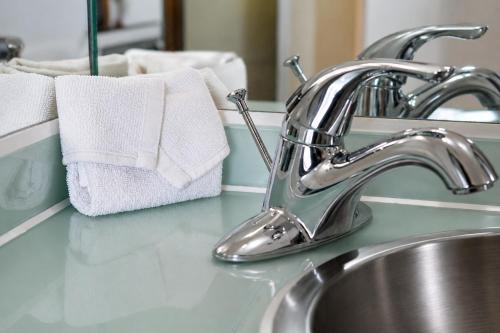 a bathroom sink with a faucet and towels on a counter at Hotel Hi! Queretaro in Querétaro