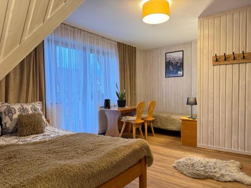 a bedroom with a bed and a table and chairs at U Hajduka in Murzasichle