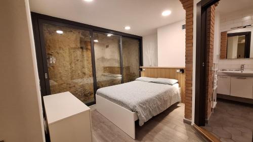 a bedroom with a bed and a bathroom with a shower at Lucas House in Bibbona