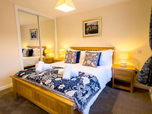 a bedroom with a bed and a large mirror at Kestrel Lodge - hot tub , sauna, EV and bike storage in Aviemore