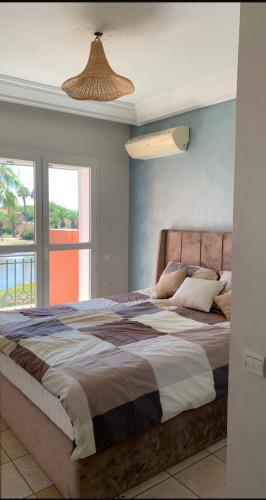 a bedroom with a large bed with a large window at Villa comfort in Bouznika