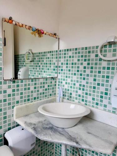 a bathroom with a sink and a mirror at Mandacaru Pousada Arraial D'Ajuda in Arraial d'Ajuda