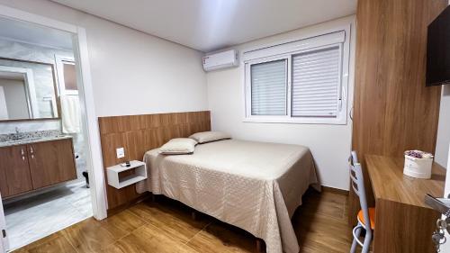 a small bedroom with a bed and a window at Restaurante e Pousada Andrade in Centenário