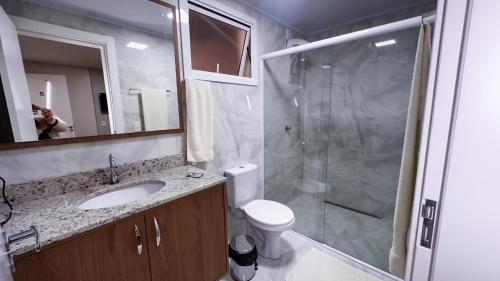 a bathroom with a shower and a toilet and a sink at Restaurante e Pousada Andrade in Centenário