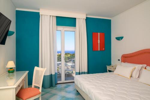 a bedroom with a bed and a desk and a window at Hermitage Resort & Thermal Spa in Ischia Town