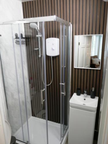 a bathroom with a shower and a toilet and a mirror at Dewsbury House in Blackpool