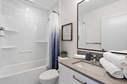 a white bathroom with a sink and a toilet at Saratoga Beach Villa 6 in Oyster Bay