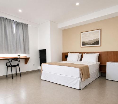 a bedroom with a large bed and a desk at Smart Hotel GRU in Guarulhos