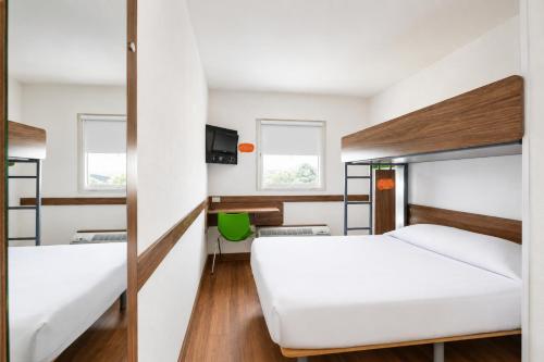 a room with two beds and a tv at Hotel Hi! Queretaro in Querétaro