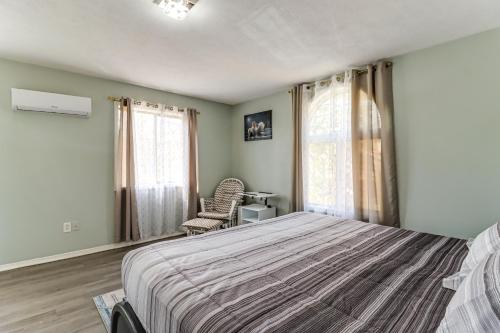 a bedroom with a bed and a chair and windows at Lake Access & Game Room! Poconos Resort Getaway in Tobyhanna