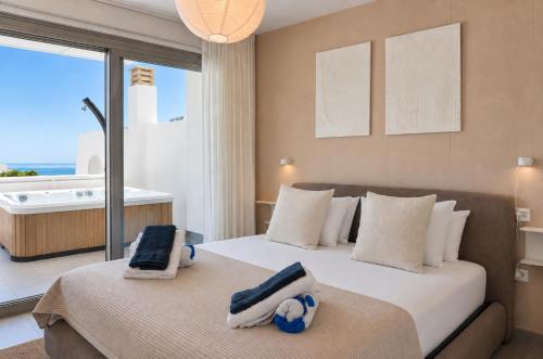 two beds in a bedroom with a view of the ocean at Altea Sol Marina Apartment by NRAS in Altea