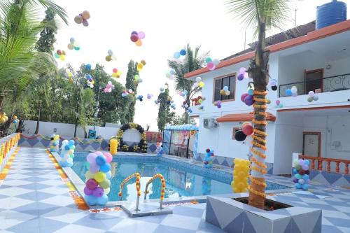 a pool at a resort with balloons and a palm tree at Chillout Villa in Wada