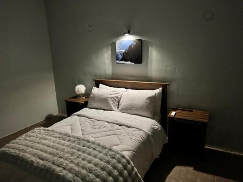 a bedroom with a bed with white sheets and pillows at Casa Flores in Río Blanco