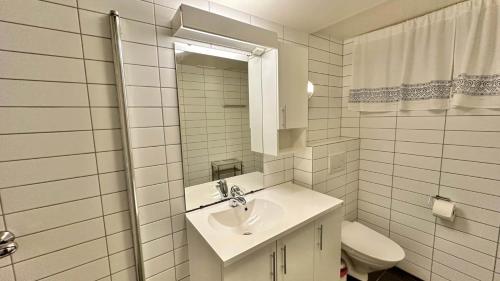 a white bathroom with a sink and a toilet at Lofotenfeeling, Haverringen Panorama in Vestvågøya