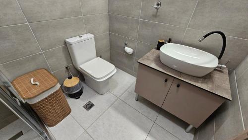 a bathroom with a white toilet and a sink at Estia Chios Apartments B3 in Karfas
