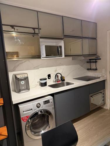 a kitchen with a washing machine and a sink at Hotel VISION in Brasília