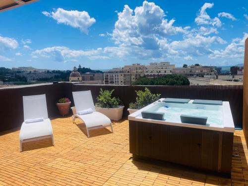 a hot tub and two chairs on a roof at Bluemoon Sardinia Roof Garden Jacuzzi in Cagliari
