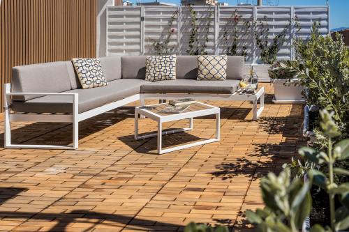 a couch and a table on a patio at Bluemoon Sardinia Roof Garden Jacuzzi in Cagliari