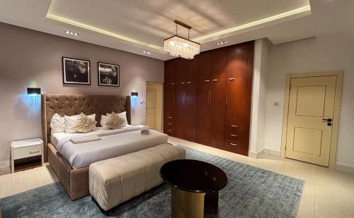 a large bedroom with a large bed and a chandelier at Mac Residence in Lagos
