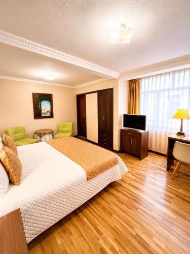 a hotel room with a bed and a television at Hotel Endamo in Latacunga