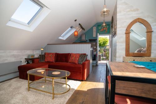 a living room with a red couch and a table at Garden View Apartment in Salcombe