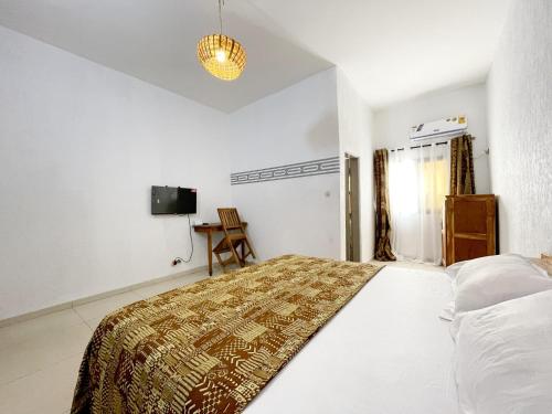 a bedroom with a bed and a television in it at Hôtel villa blanca in Lomé