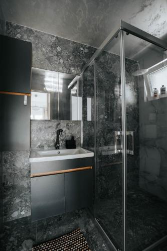 a bathroom with a sink and a shower at Bubbles 2 Apartments in Gevgelija