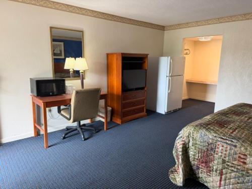 a hotel room with a bed and a desk with a computer at Wethersfield Motel in Wethersfield