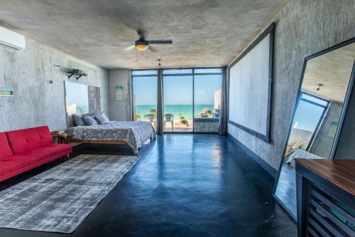 a living room with a red couch and a bed at Puerto del Cielo in Chuburná
