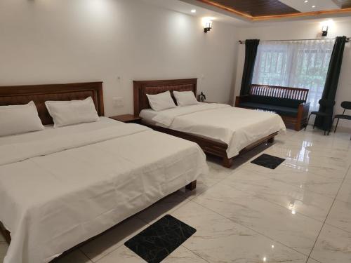 a hotel room with two beds and a couch at Mistora Estate Villa in Suntikoppa