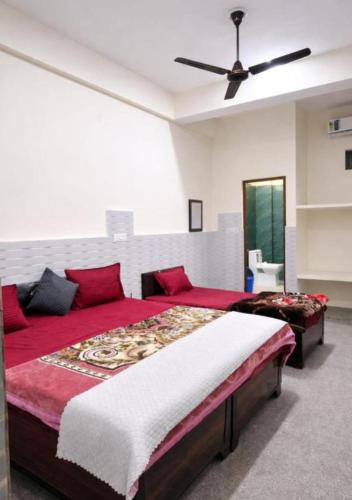 a bedroom with a large bed and a ceiling fan at Hotel Badri Palace in Rishīkesh