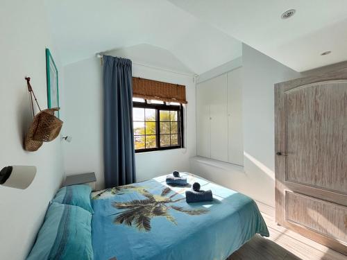 a bedroom with a bed with blue sheets and a window at Fuerte premium blue in Costa Calma