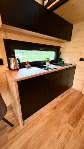 a kitchen in a tiny house with a stove at Mazurski Widok 2 in SzczybaÅ‚y OrÅ‚owskie