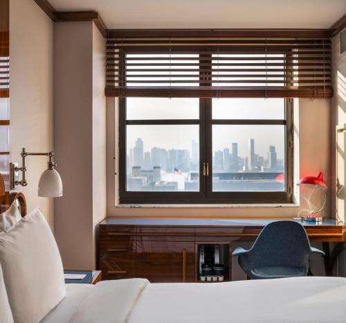 ein Schlafzimmer mit Fenster, Schreibtisch und Stuhl in der Unterkunft Hotel Hugo in New York