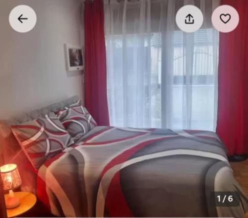 a bedroom with a bed with red curtains and a window at Chambre chez Danuta in Champagnole