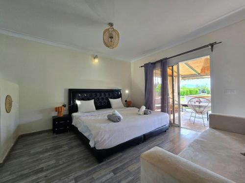 a bedroom with a large bed and a balcony at Admylla in Sraghna
