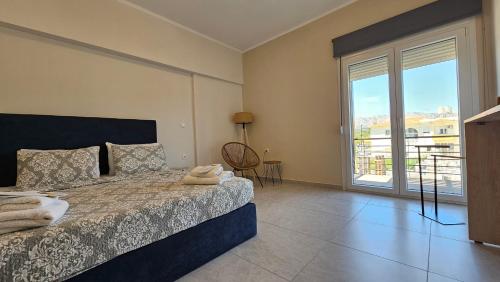 a bedroom with a bed and a large window at Estia Chios Apartments B6 in Chios