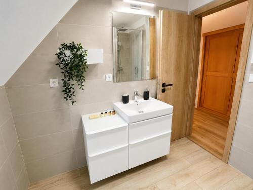 a bathroom with a white sink and a mirror at Chalupa pod Špičákem in Smržovka