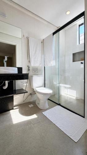 a bathroom with a toilet and a glass shower at Smart Hotel GRU in Guarulhos