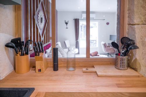 a kitchen counter with utensils and a mirror at Le Repaire d'Argenson in Bergerac