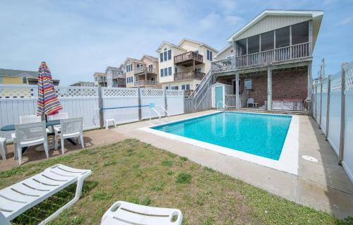 a swimming pool in a yard next to a house at Fun 'N Sun - Nags Head MP 16, 250 Ft to Beach Access, Pool, Pets OK, YR Flex Stays in Nags Head