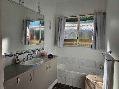 a bathroom with a sink and a tub and a mirror at Hopetoun - footprints in the sand in Hopetoun