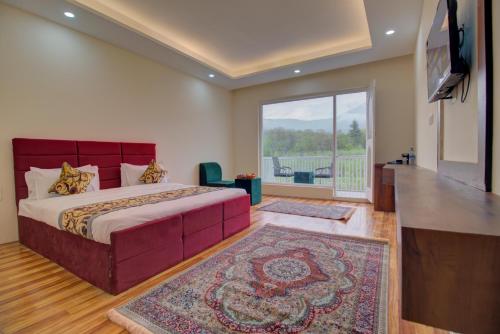 a bedroom with a large bed and a balcony at Royal Cliff Resort Pahalgam in Pahalgām